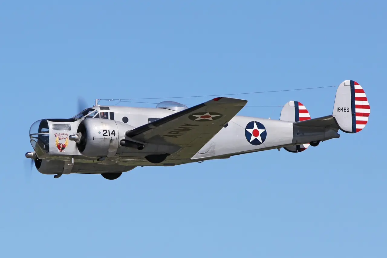 A vintage military bomber plane flying in clear blue sky.