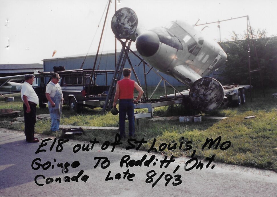 Vintage airplane on display at an outdoor event with people around.